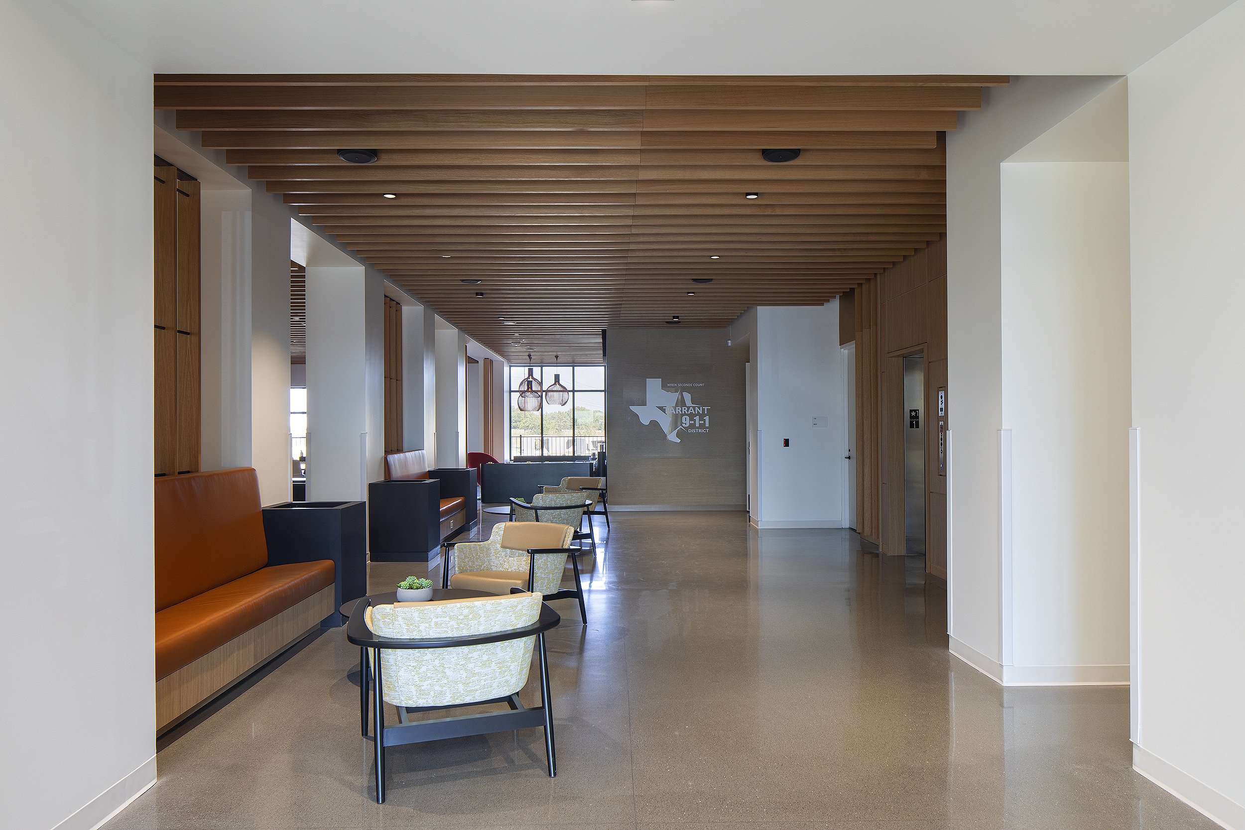 Entry way to office with seating area and wait room elevators to the right