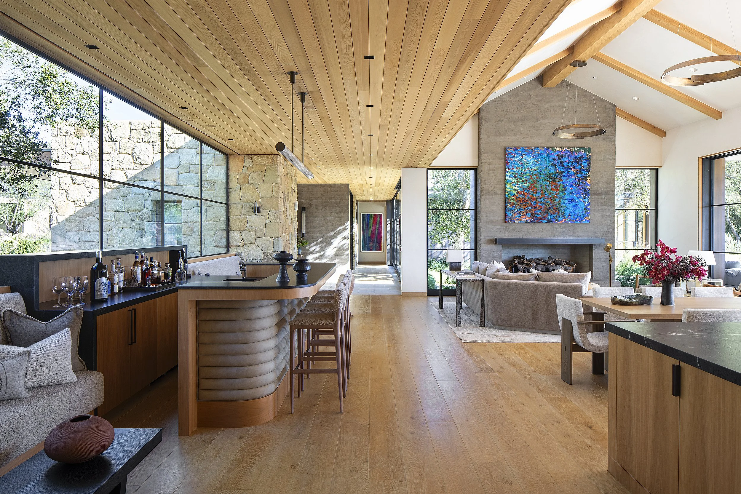 Interior home with bar wrapped with leather and blue colorful painting above fireplace Santa Barbara, California 