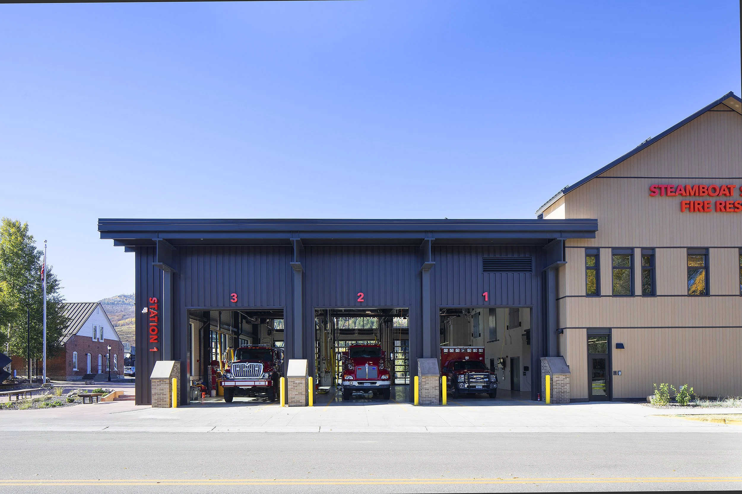 Steamboat Springs fire station with bay doors open with three fire trucks