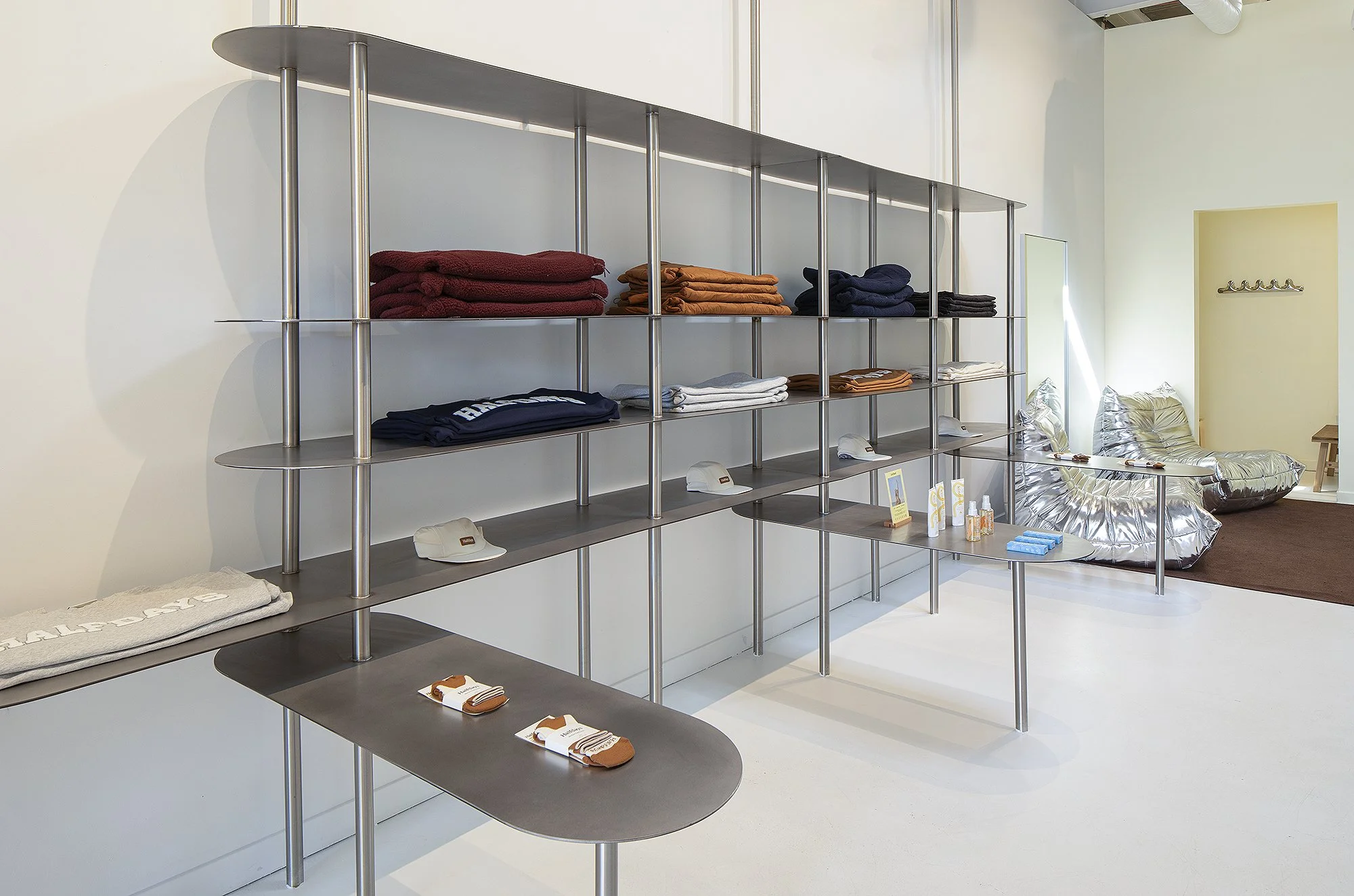 Silver display shelving displaying clothes in Half Days retail store in Denver