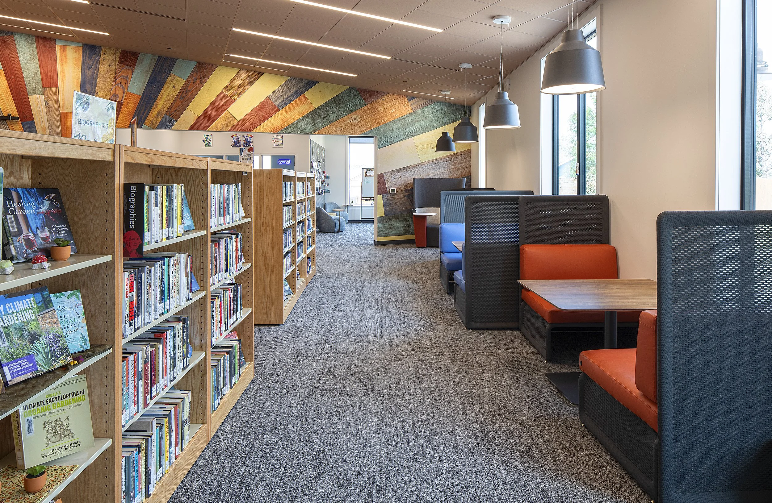 Library with orange chairs and table for studying. Colorful wall in the background