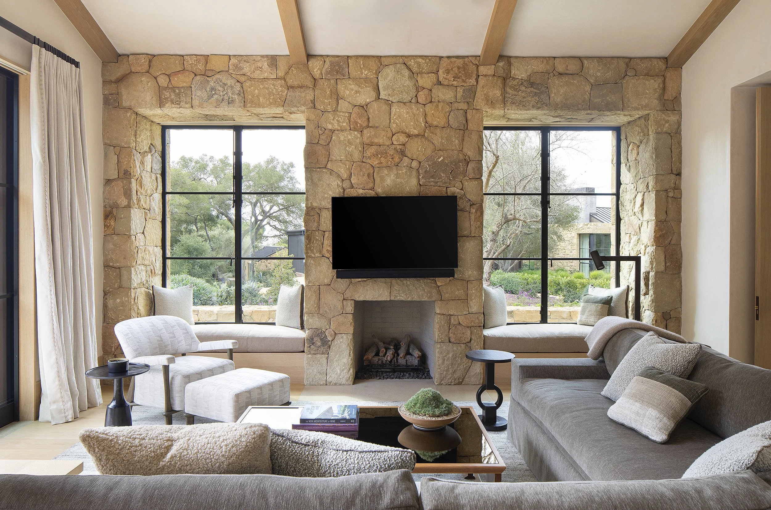Small living room in guest house with tv on rock wall 
