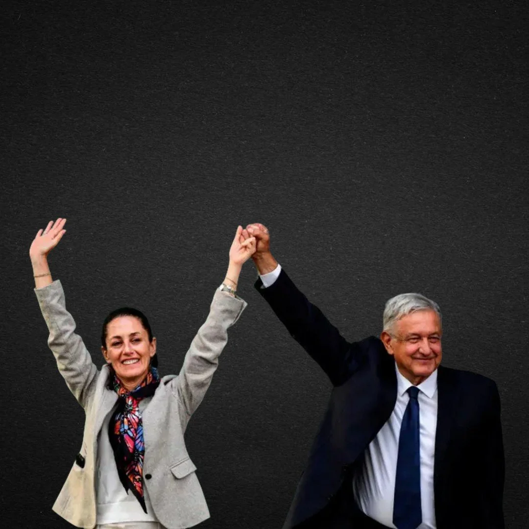 Una mujer y un hombre en traje celebrando y levantando las manos en señal de victoria o triunfo.
