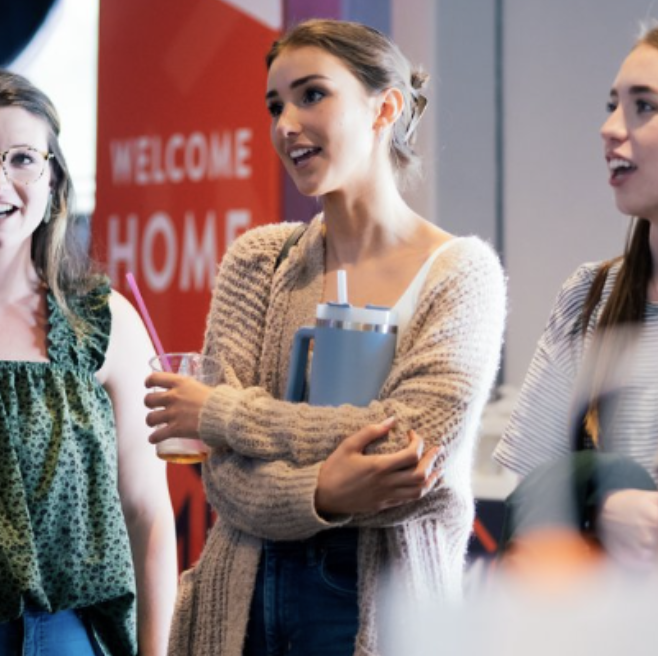 Group of young women chatting indoors with a red 