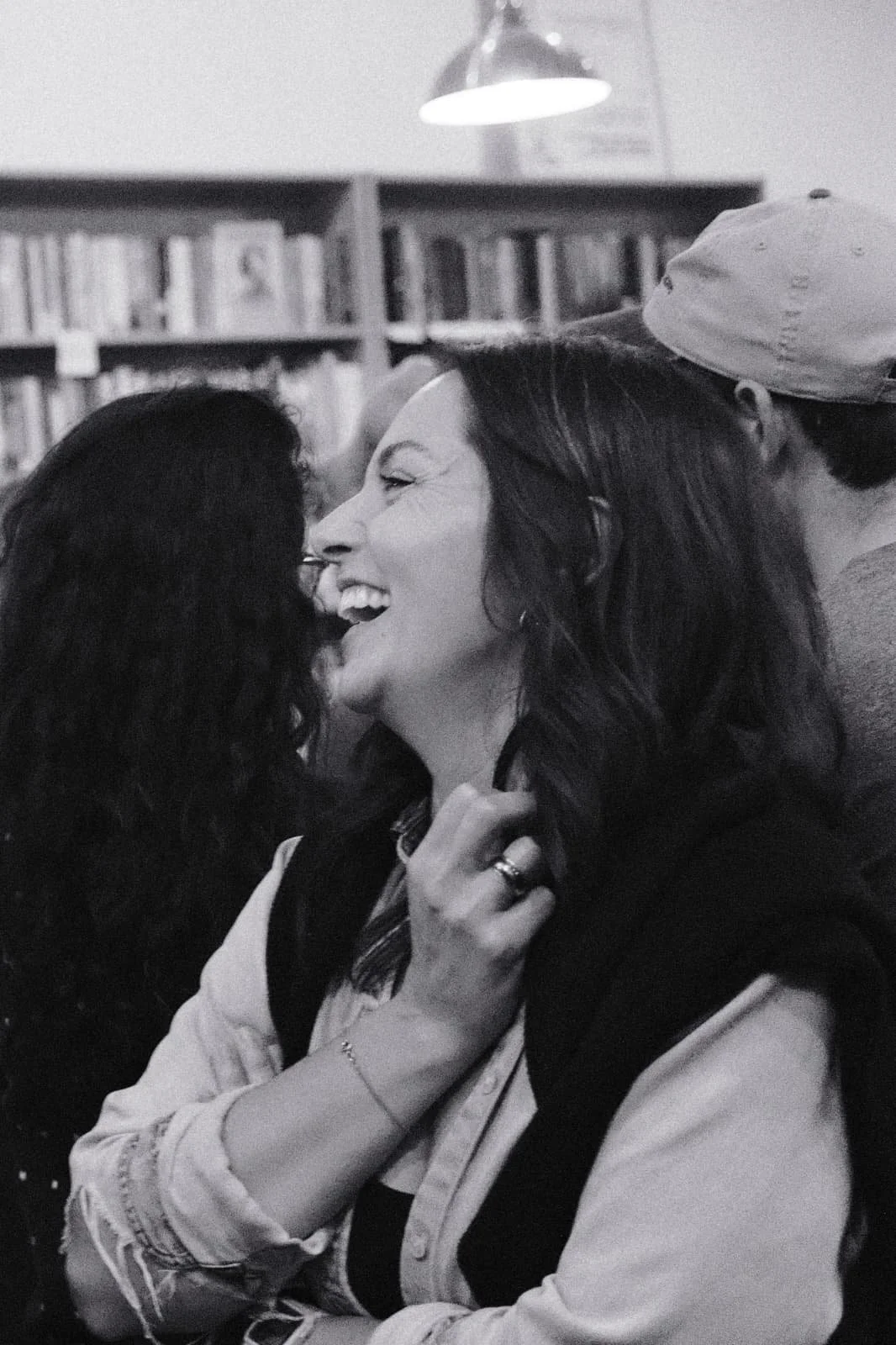 Annelise Schoups is a Chicana Belgian-American woman. The image is in Black and White. Annelise is in profile, laughing.