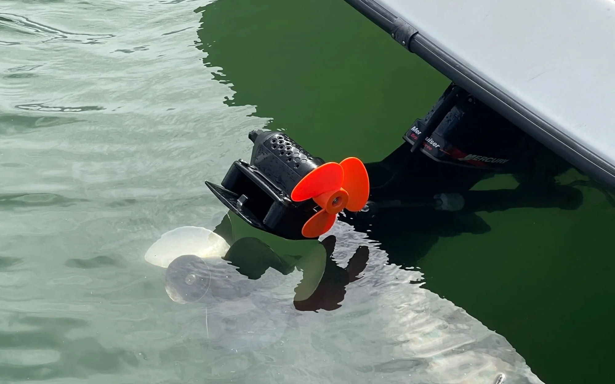 A boat's Mercury Bravo Three outdrive with a stern thruster mounted on the cavitation plate, a GTD marine rock solid clamp on SidePod thruster.