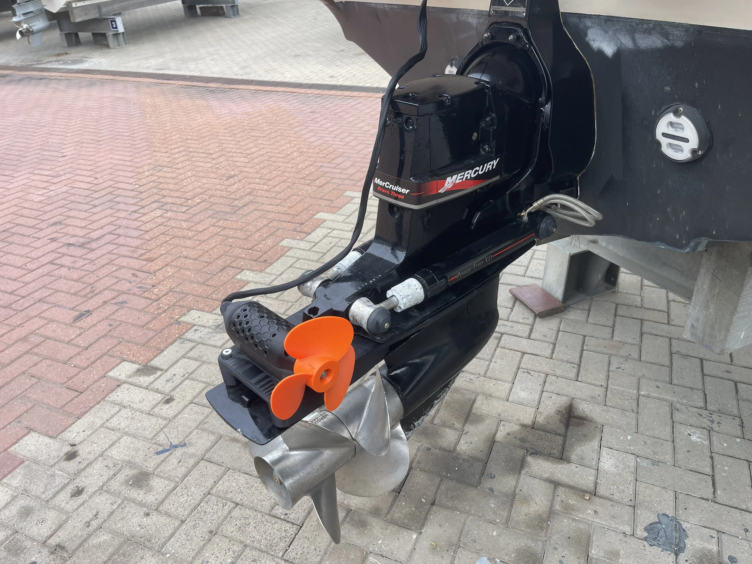 Close-up of the motor and propeller of a boat's Mercury Bravo Three outdrive with a stern thruster mounted on the cavitation plate, a GTD marine rock solid clamp on SidePod, no drilling of holes required.