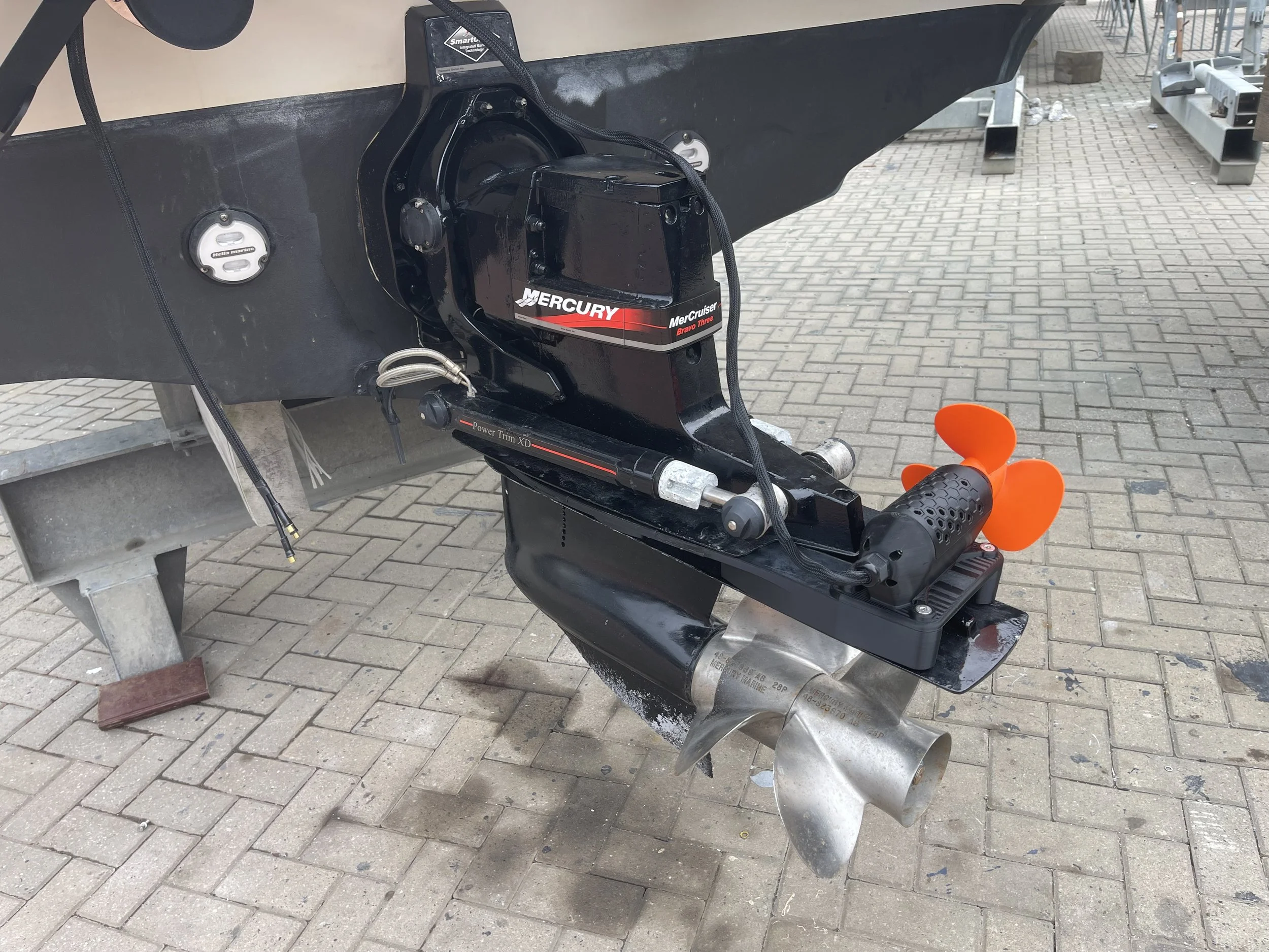 Outboard motor (Mercury Bravo Three) attached to the stern of a boat, A Mercury Bravo Three outdrive with a stern thruster mounted on the cavitation plate, a GTD marine rock solid clamp on SidePod, no drilling of holes required.
