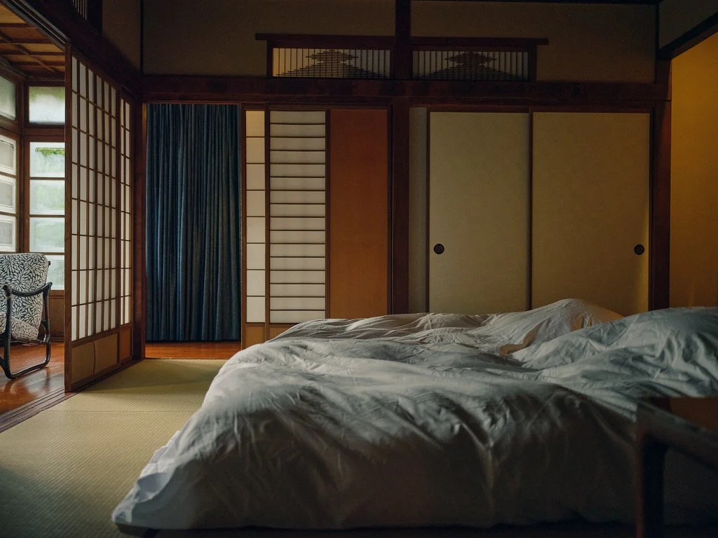 Bedroom with shoji doors, tatami flooring, and a bed with white bedding.