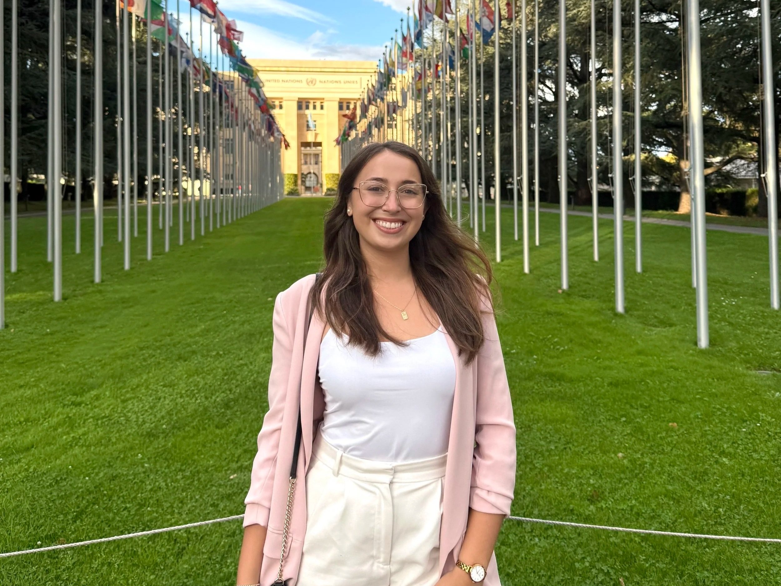 Picture of Alexandra Quintana in Geneva with the United Nations flags and building in the background