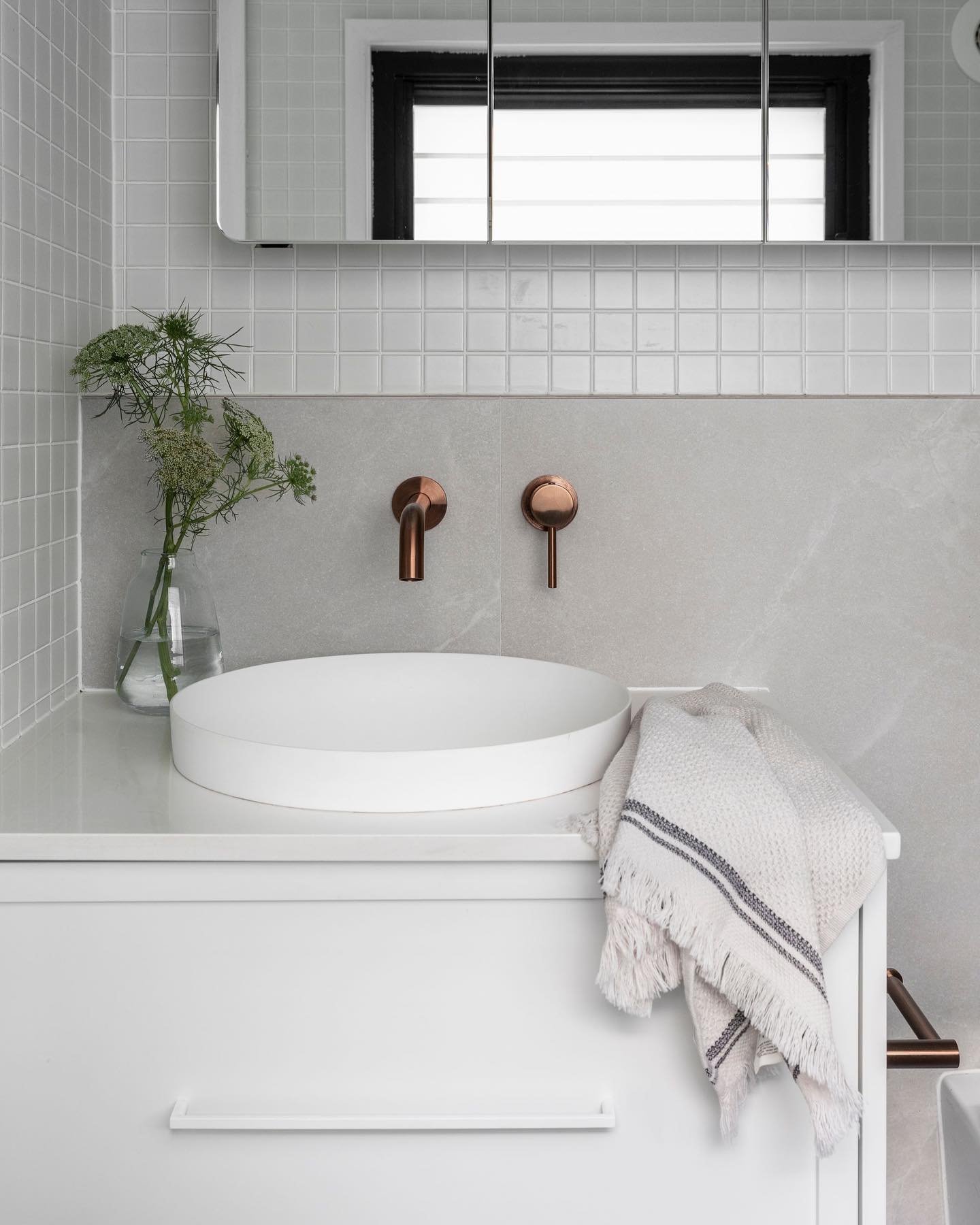 🛀 bathroom details ✨ 

A white on white bathroom could present as cold and clinical. The selection of matte surfaces (tiles, matte sink) softly diffuses light around the room and the copper fixtures bring out the warmer tones in the accent stone til