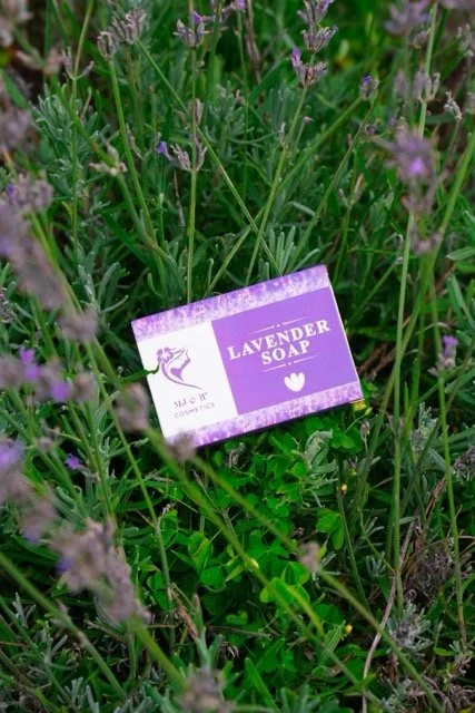 Lavendar soap in a field of lavendar on a beautiful sunny day, packaging is purple and white. 