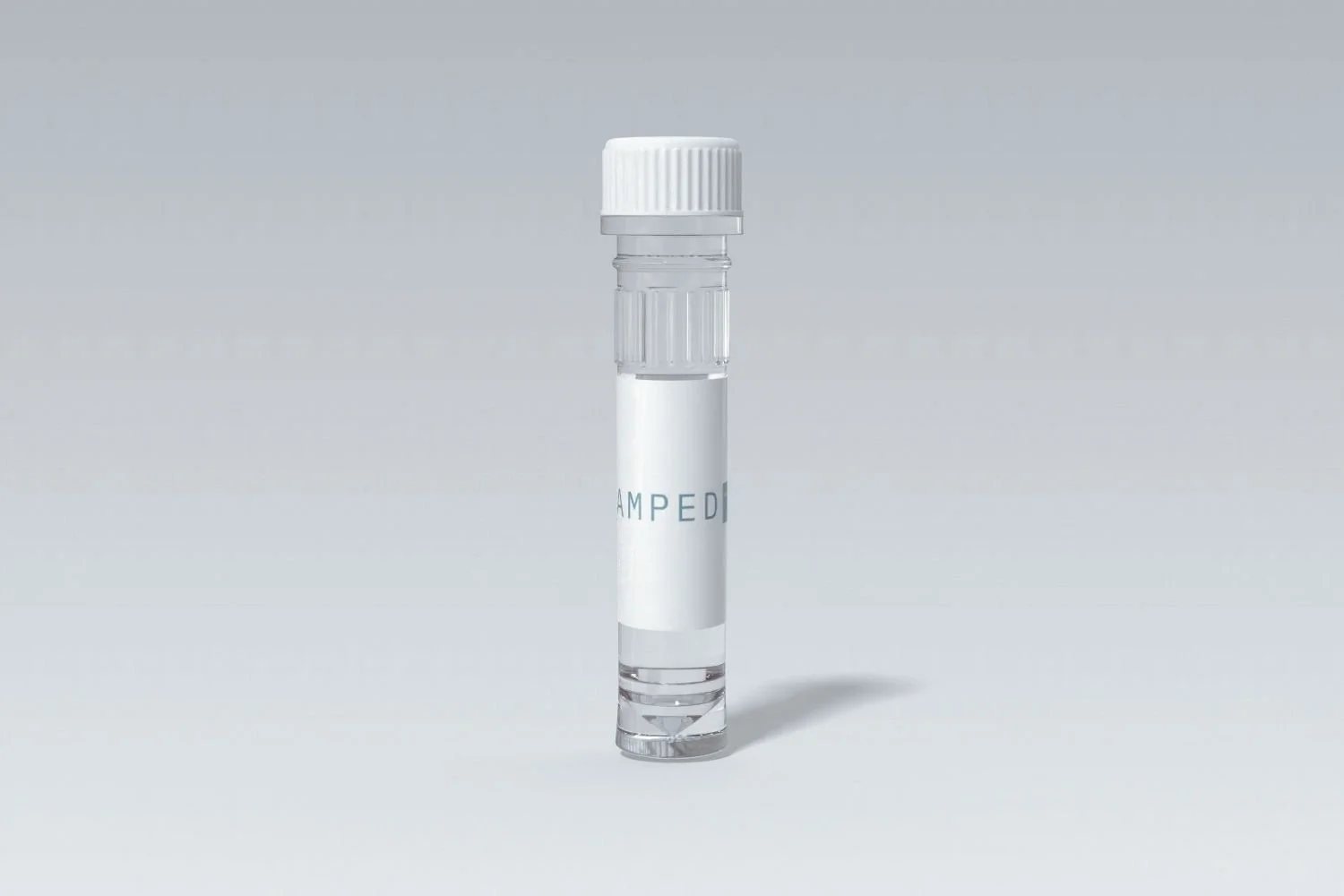A clear vial with a white cap and a blank white label, placed on a white surface with a subtle shadow.