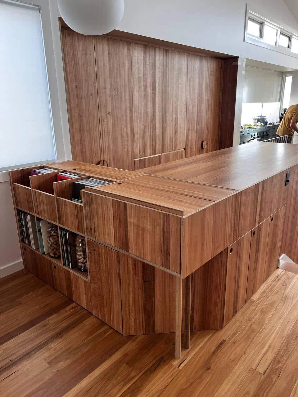 A wooden kitchen island with open shelving and cabinets in a modern kitchen.