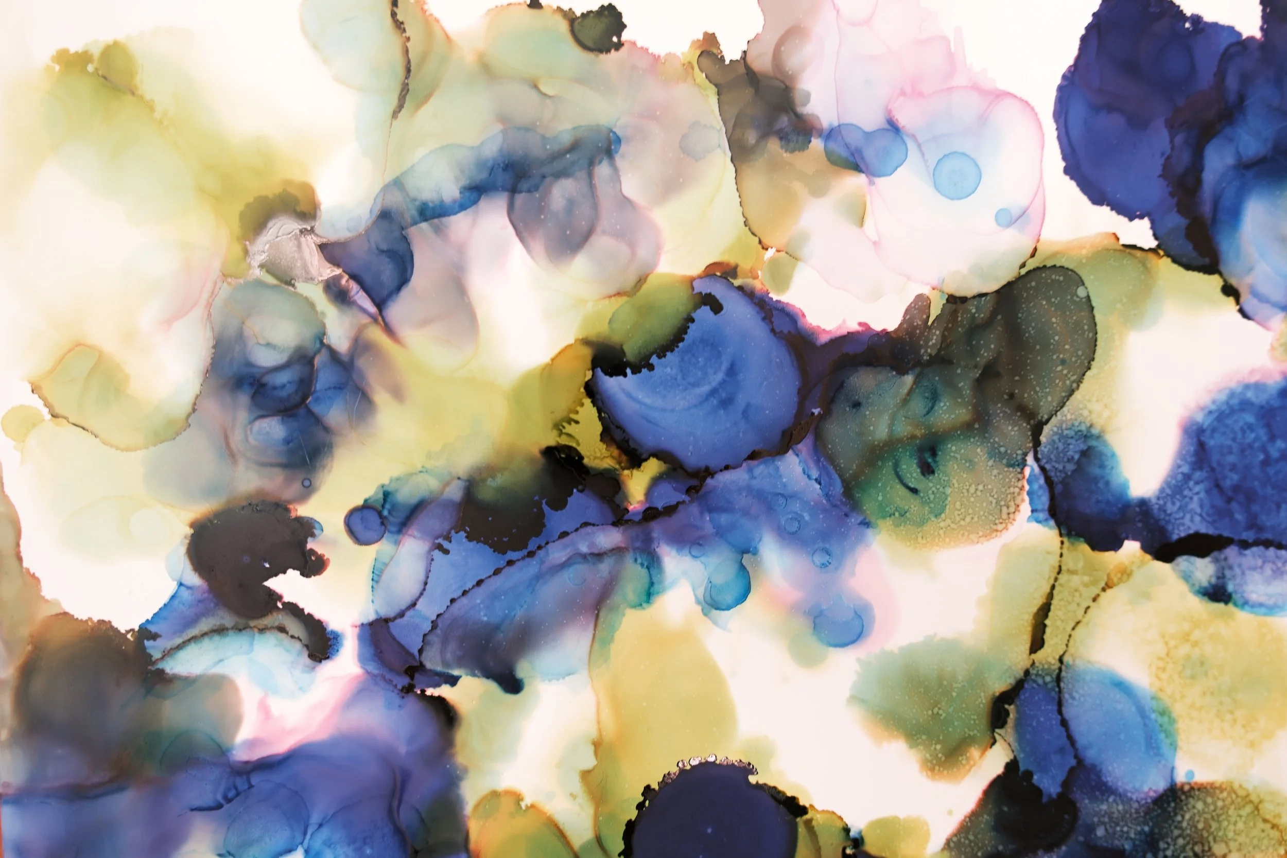 Abstract schilderkunst met vlekken van blauw, geel, groen en roze in waterachtige textuur.