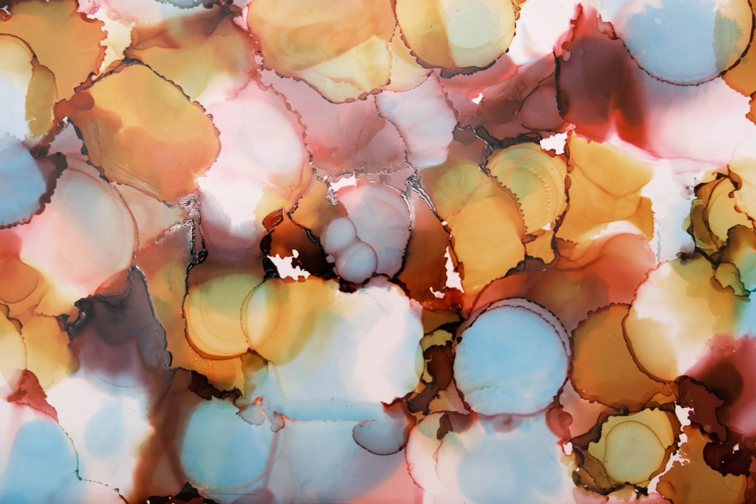 Abstract watercolor painting met ronde vormen in warme tinten van geel, oranje, rood, bruin en zacht blauw, met zwarte lijnen die de vormen omlijnen.