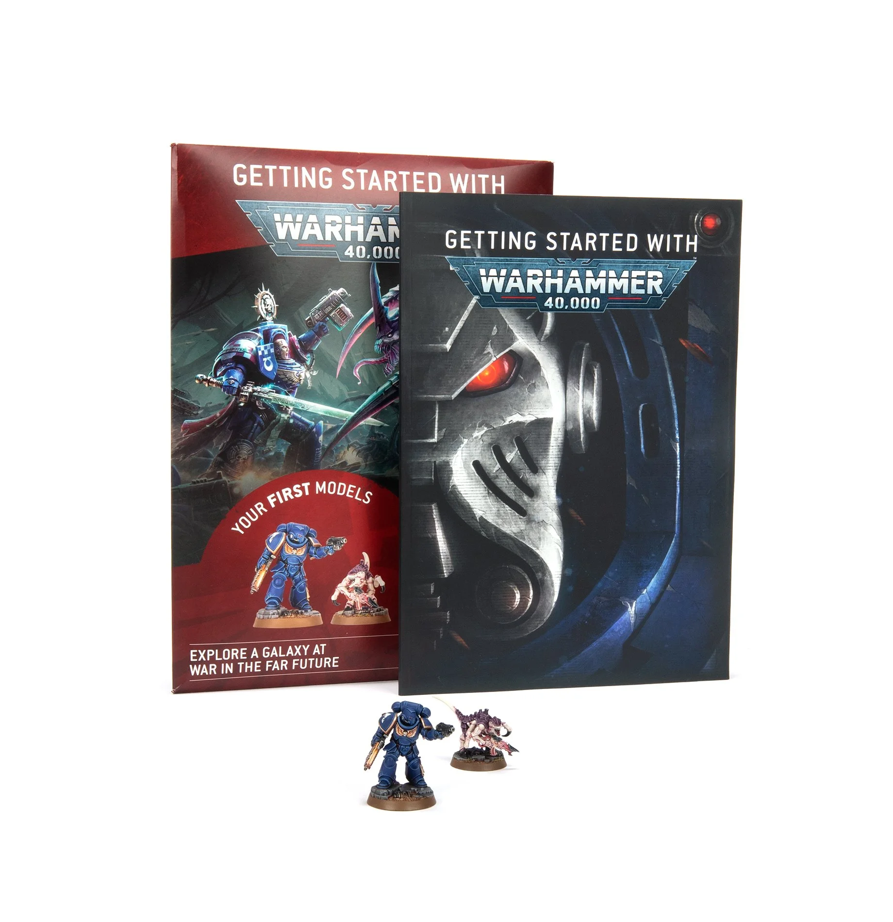 Warhammer 40,000 beginner box and miniatures, with a booklet and two figurines, one in blue armor and one in purple with a beard, on a white background.