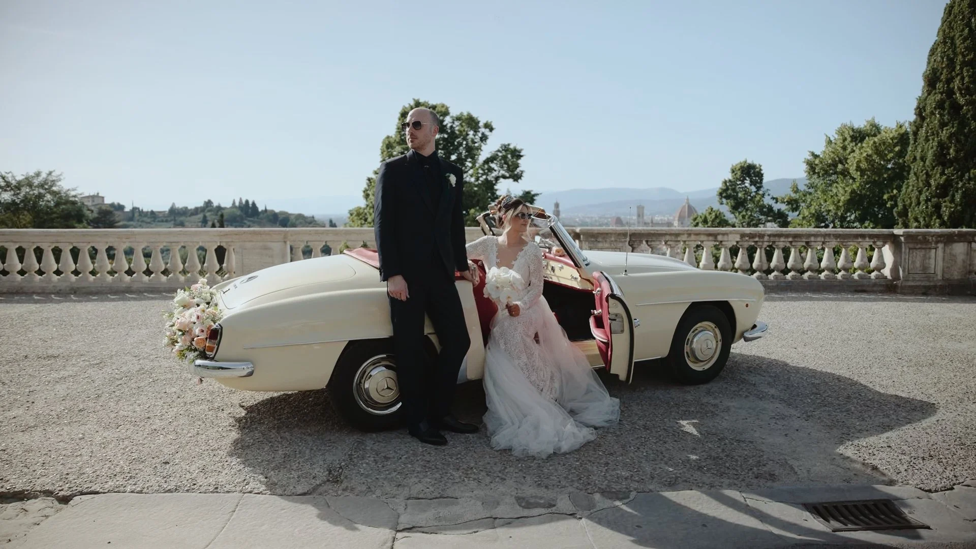 Editorial wedding videography in Florence: Couple with a vintage Mercedes overlooking the Duomo at Villa di Maiano.