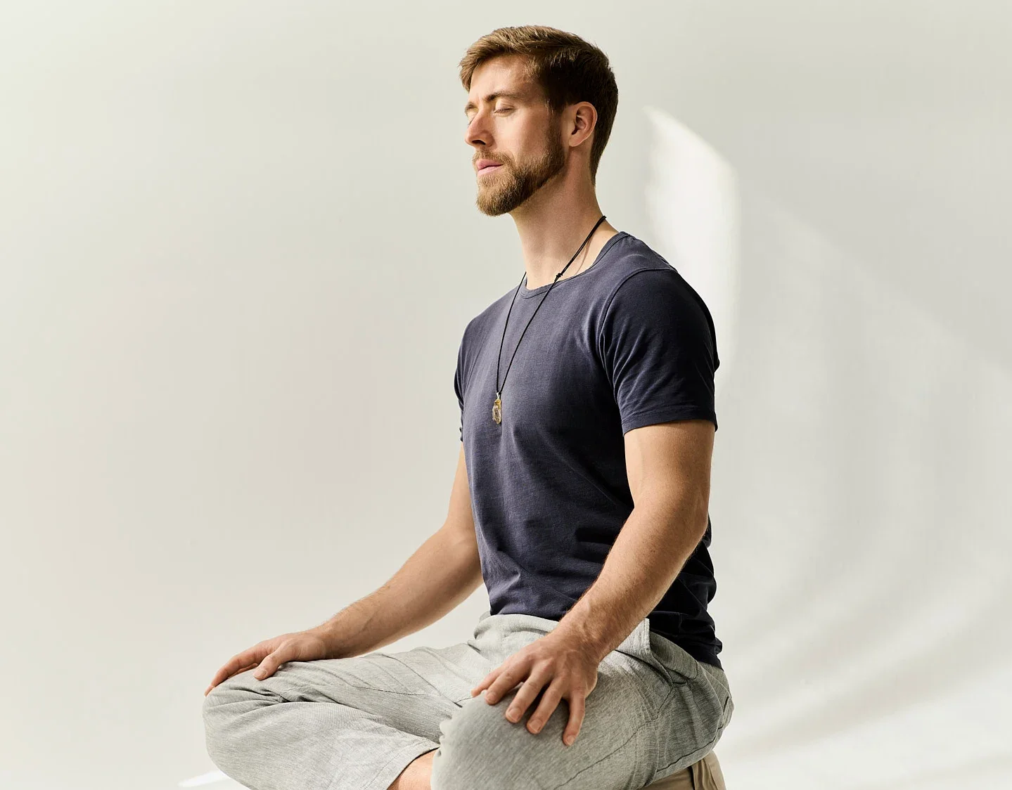 Tobias Garnjost, Coach für innere Klarheit und achtsame Entscheidungen mit geschlossenen Augen in Meditationshaltung.
