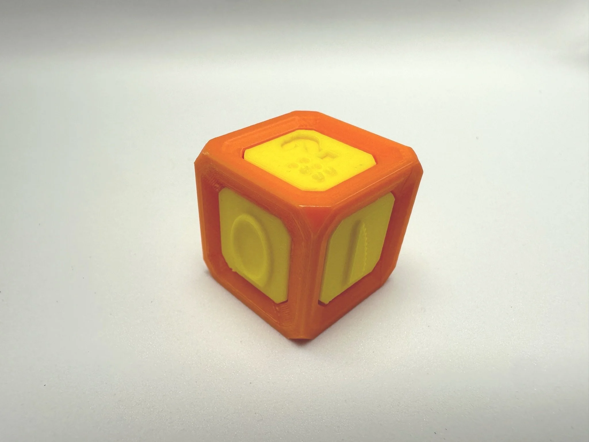 Yellow tactile faces on an orange die feature the spoon, knife, and question mark sides.