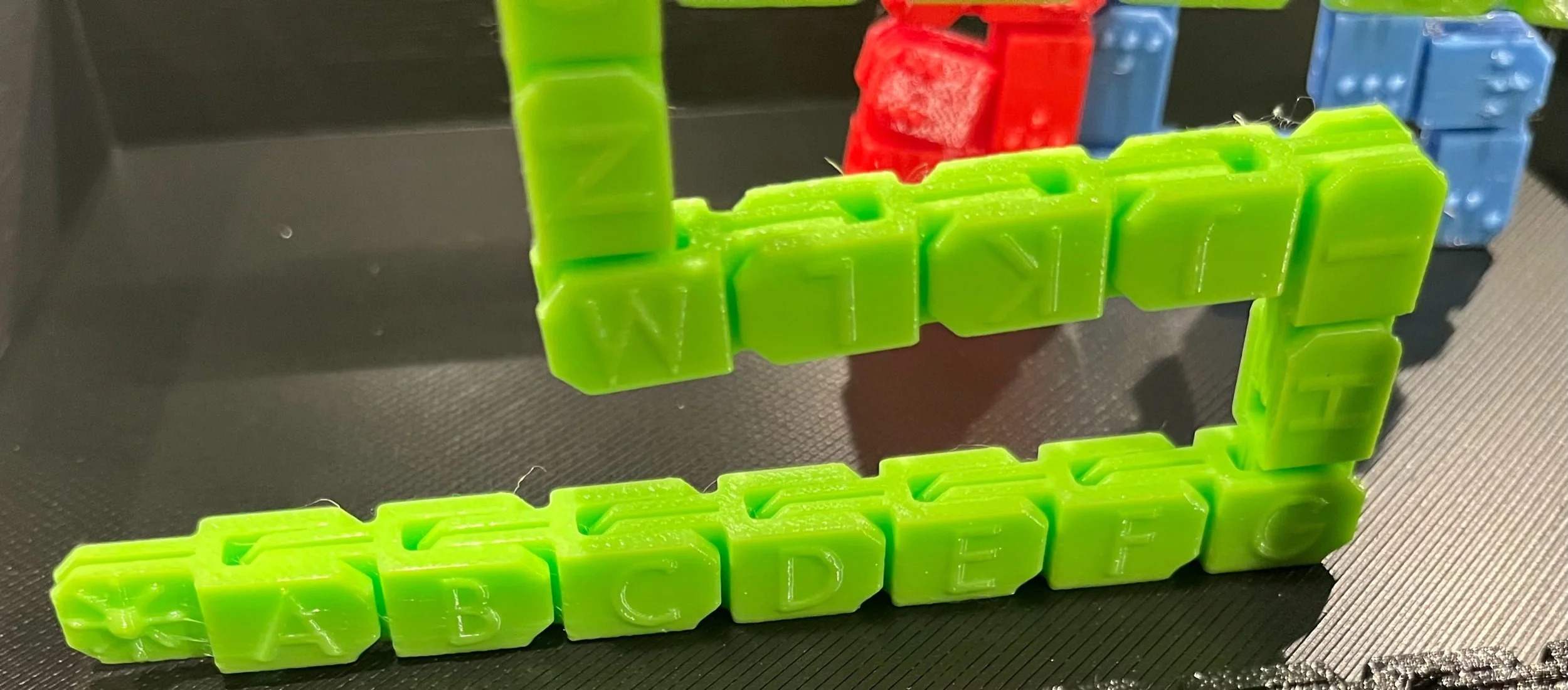 Lime green fidget folded into a zigzag configuration, print side facing out.