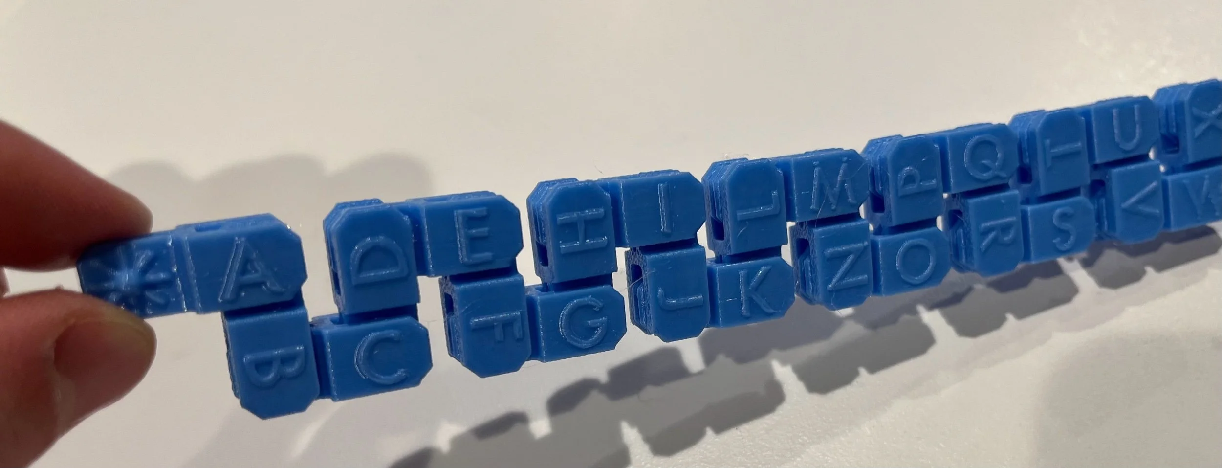 Sky blue fidget with the print side showing and folded into an accordion pattern.