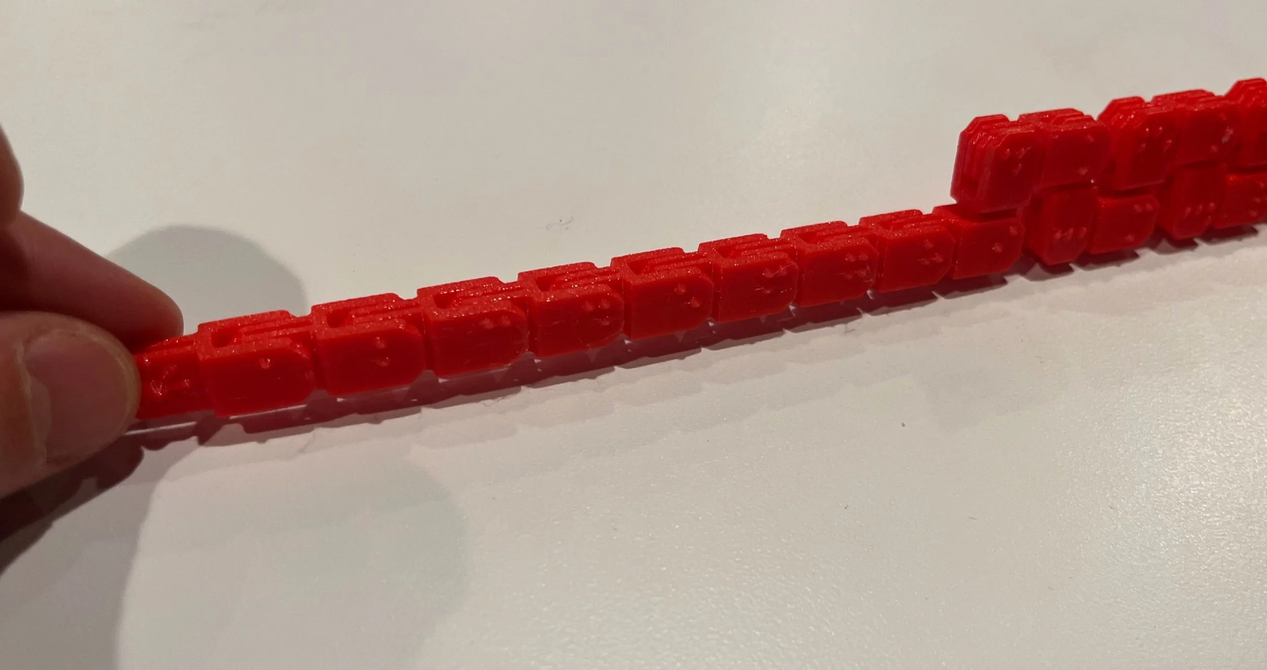 Red fidget in a straight line, braille character side facing out.