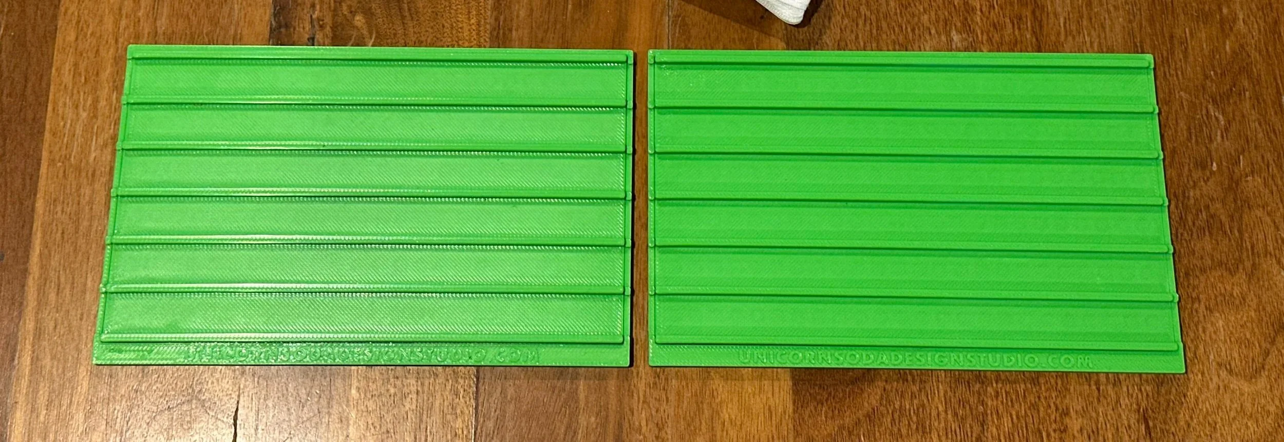 2 green slide boards against a wooden surface.