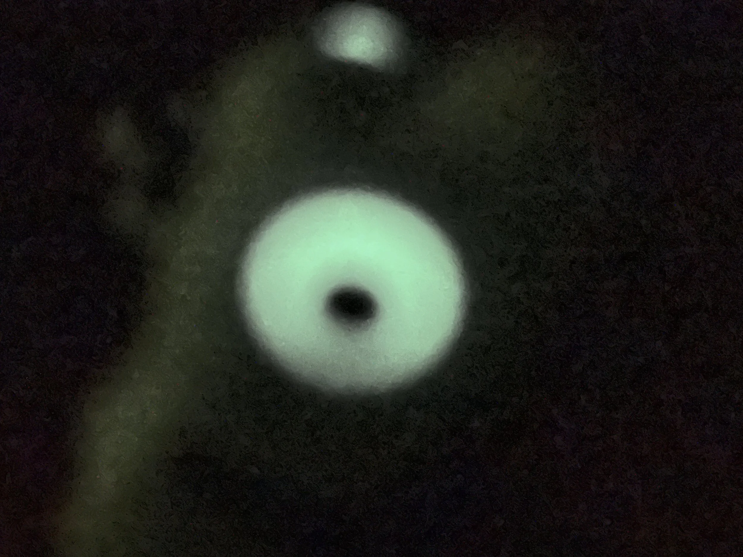 Close up in the dark of one glow in the dark eye, glowing green.