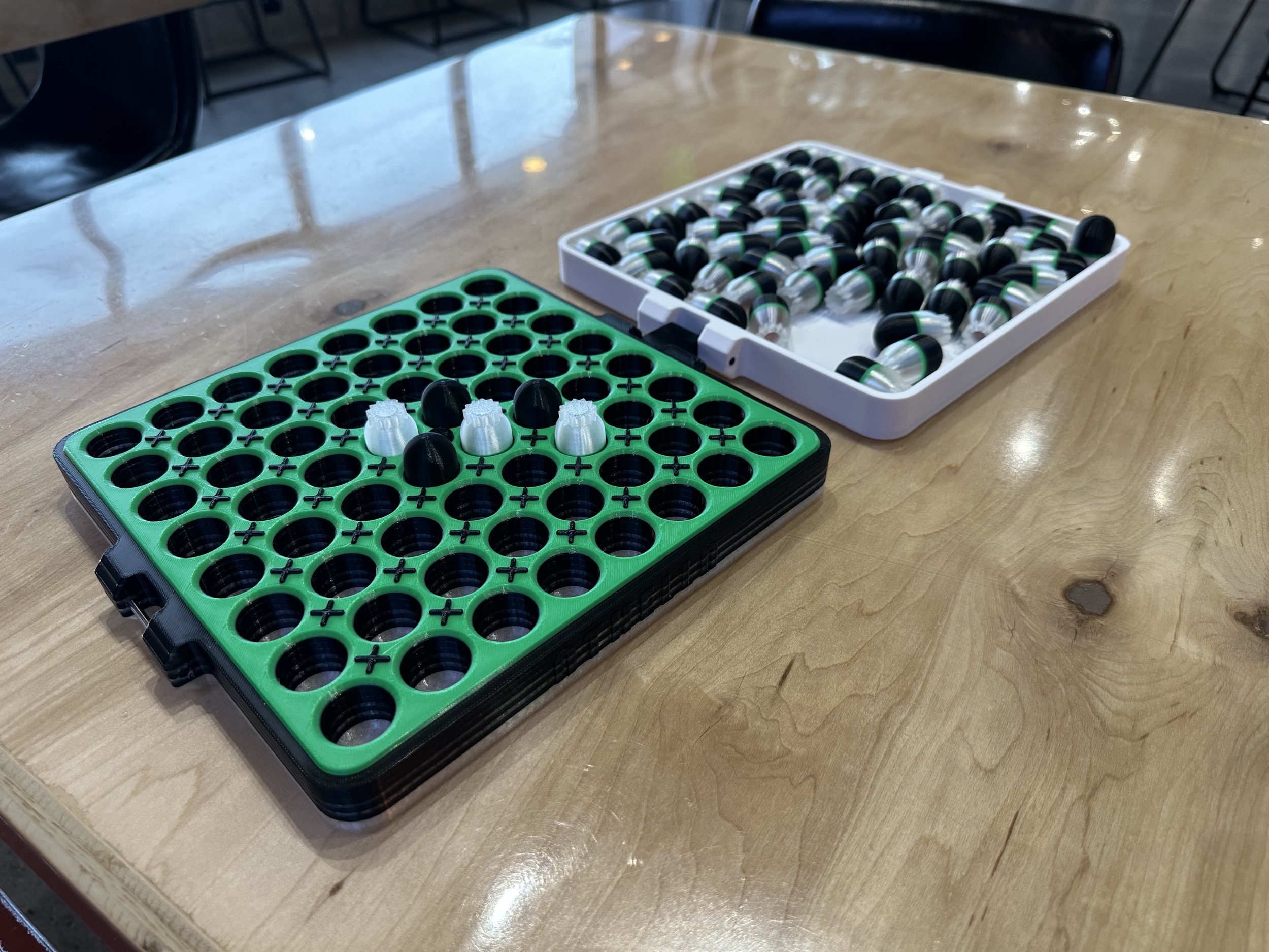 Open Othello game with a few pieces in the grid, and the unused pieces being stored in the top of the case.