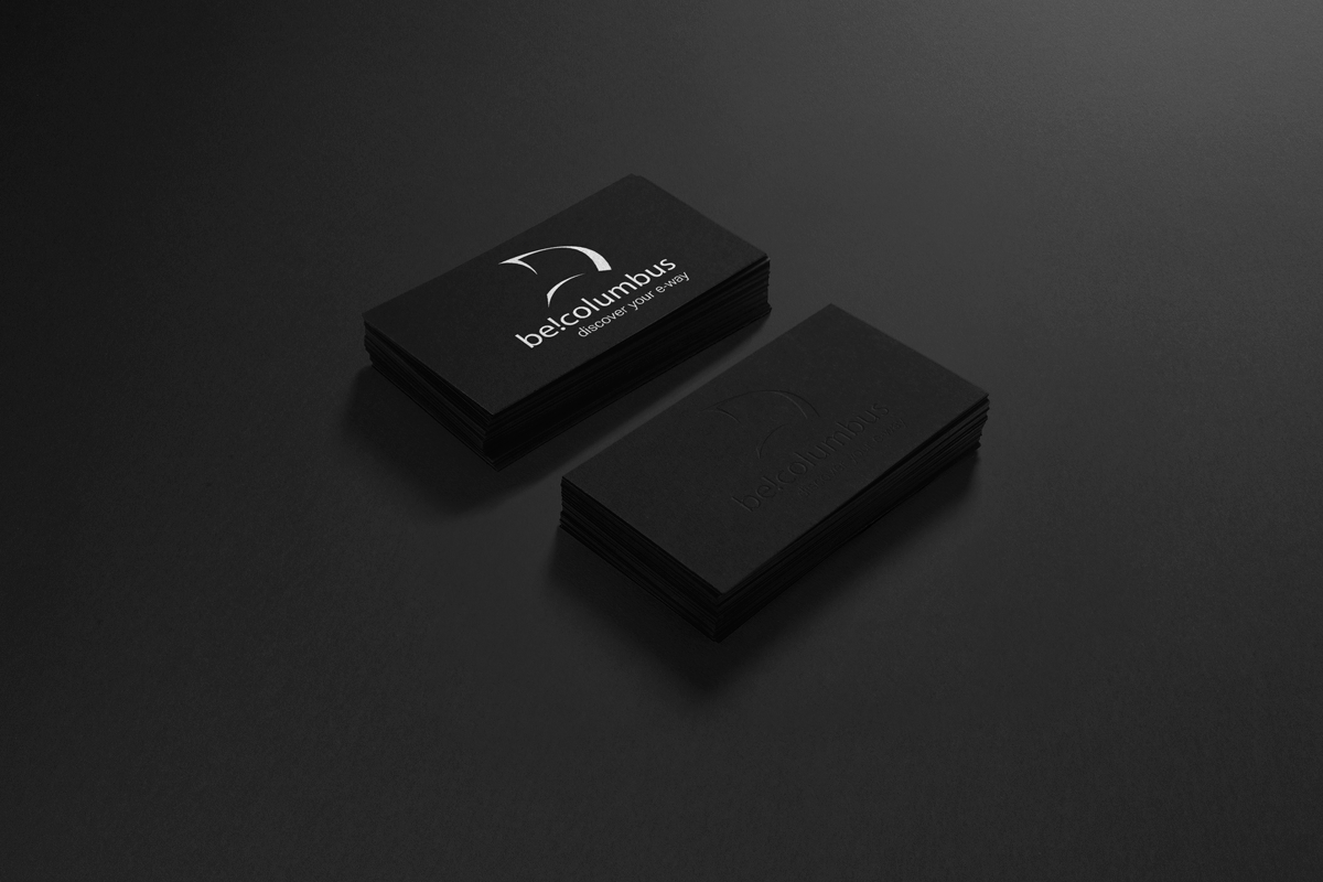 Stack of black business cards on a dark surface, with one card displaying a white logo and text reading "bel. Columbus discover your e.way".