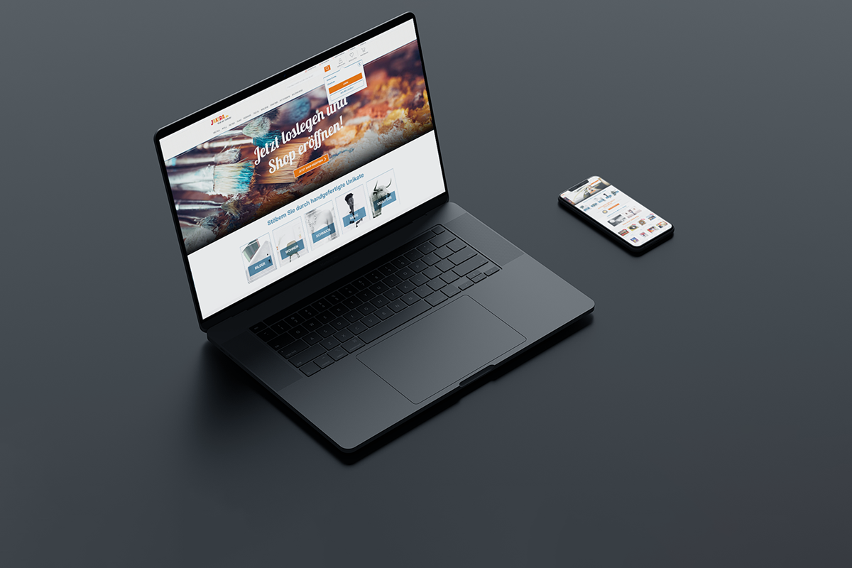 A black laptop and smartphone on a gray surface, both displaying online shopping websites.