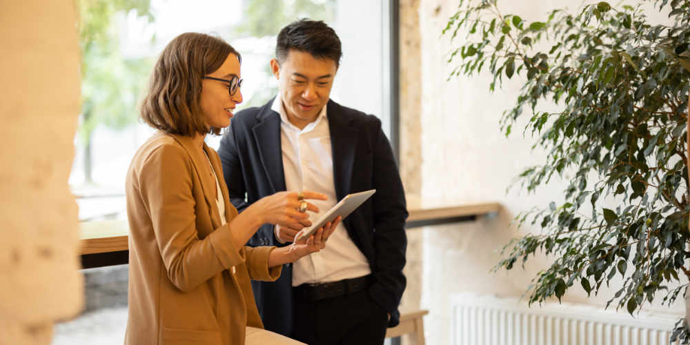 Woman and male colleague in conversation at work, reflecting menopause awareness, inclusive policies, and supportive workplace culture
