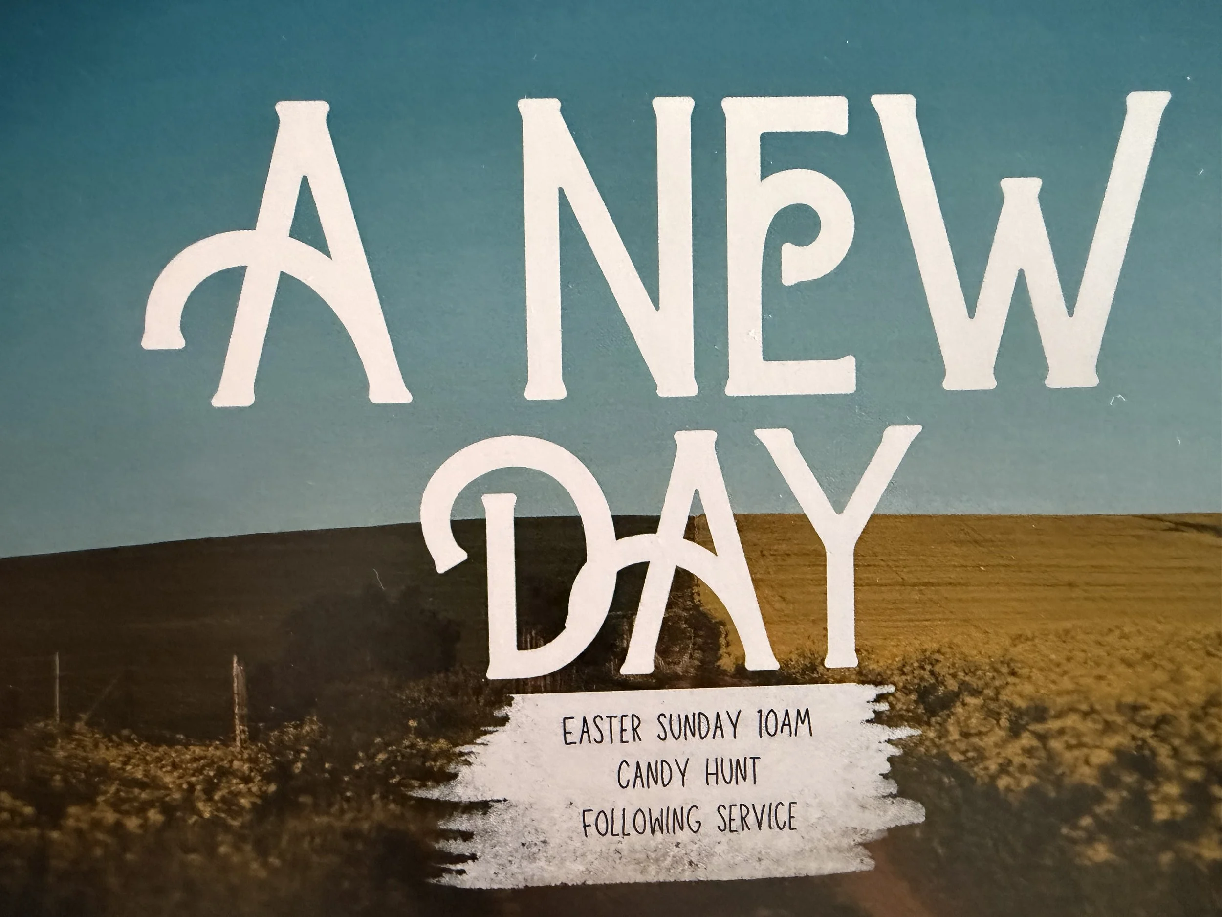 A poster for a church event titled 'A New Day' with details about Easter Sunday service at 10AM, a candy hunt, and a following service, against a rural landscape background with clear sky.