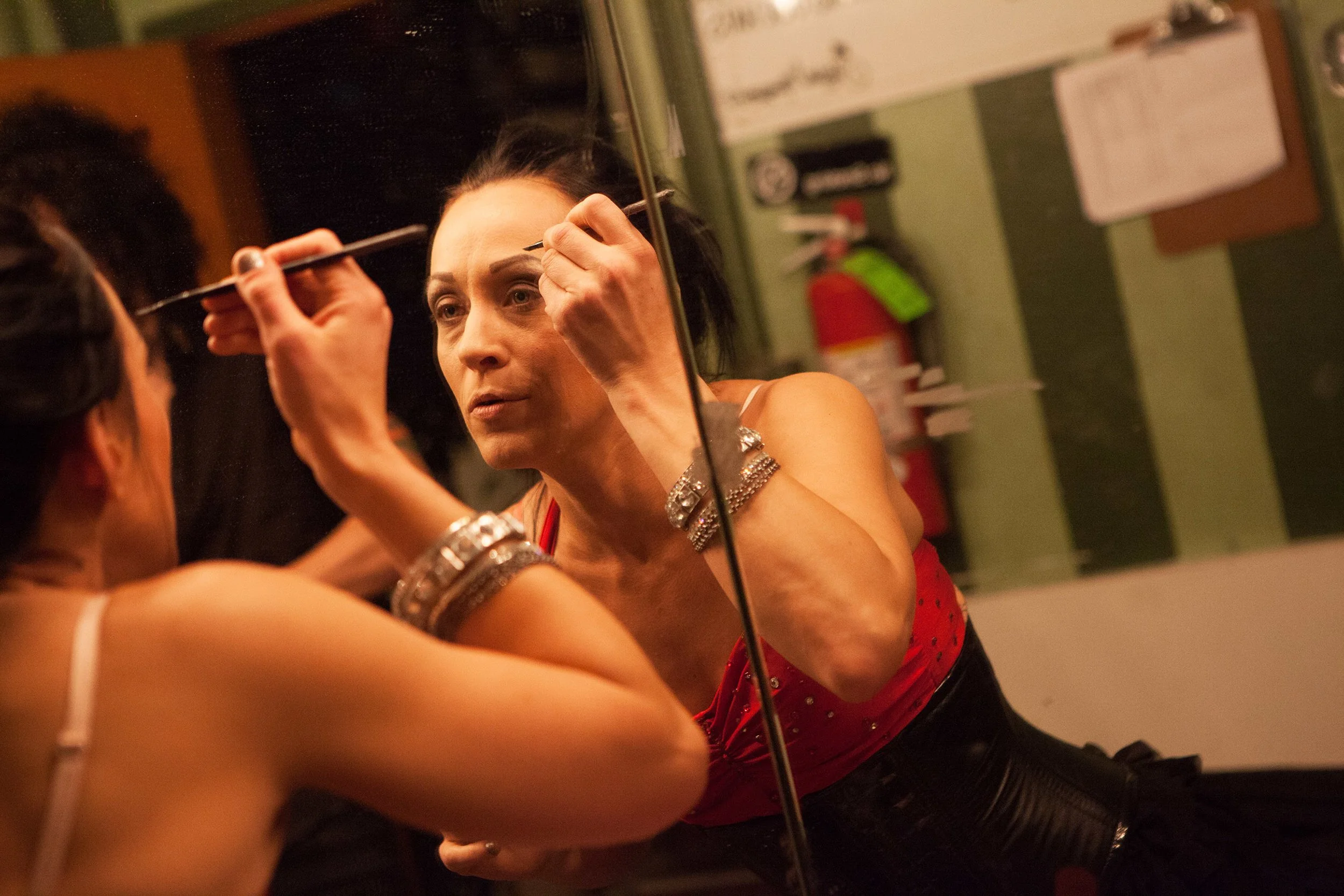 Betty Bloomerz applies makeup backstage before performing. Prior to sword swallowing, she worked as a yoga teacher.