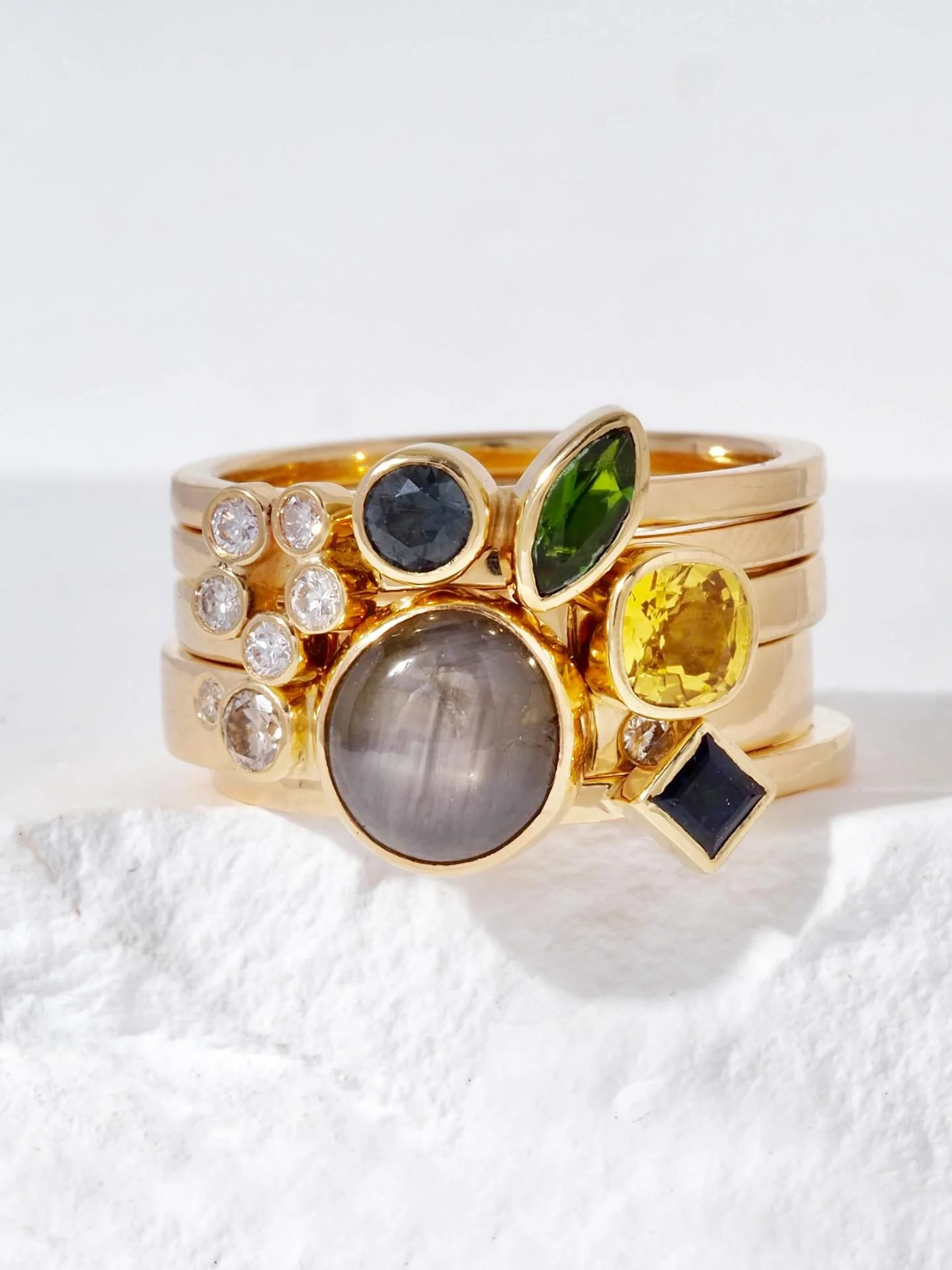 Five rings make up this elegant stacked ring set. Lots of color and sparkle in the sapphires and diamonds. There&rsquo;s a floral element as well. Repurposed and ethically sourced stones set in recycled gold. There are many ways to stack this set, we