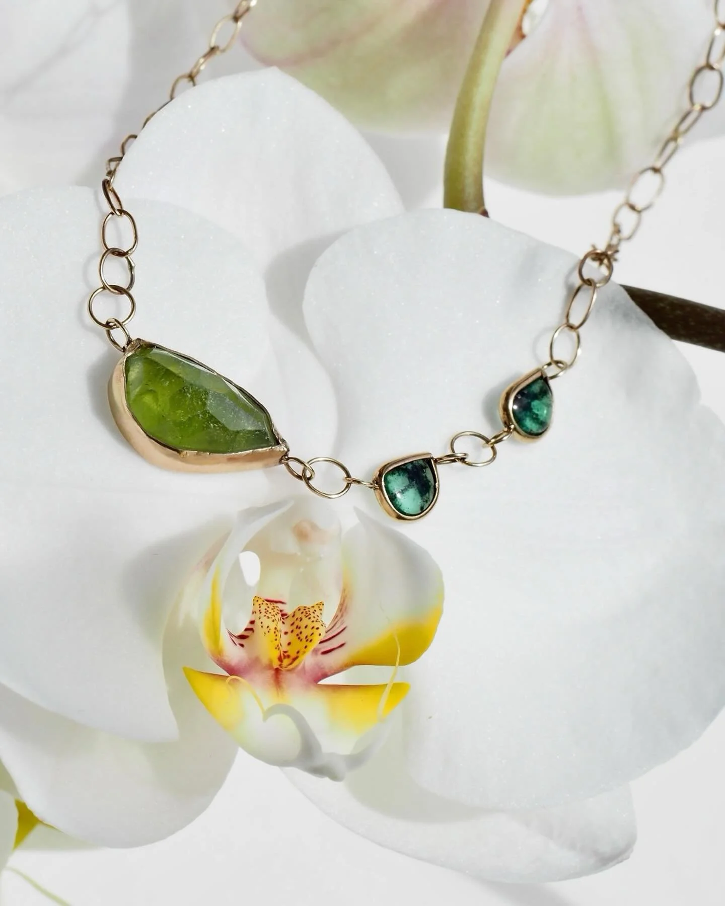 This special necklace was designed and built around three glowy green gemstones with unusual shapes. Sally bezel set them and hand fashioned the links for the chain that holds it all together using a custom mix of recycled gold. #Green #MadisonValley