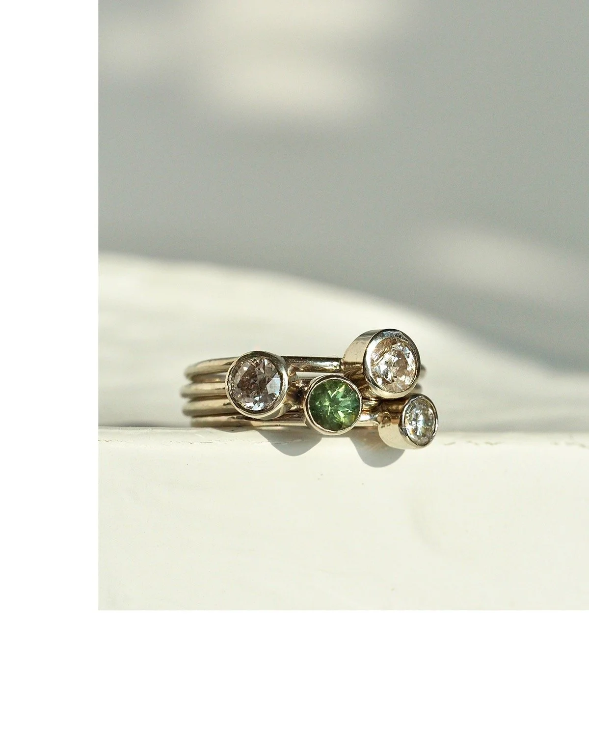 The simplicity of a diamond solitaire stack set in recycled platinum with super comfortable rounded bands. Adding in one ring with a color gemstone, personalizes the set and makes the sleek style even more modern. #StackEmHigh #Jenga #PNWmade #Seattl