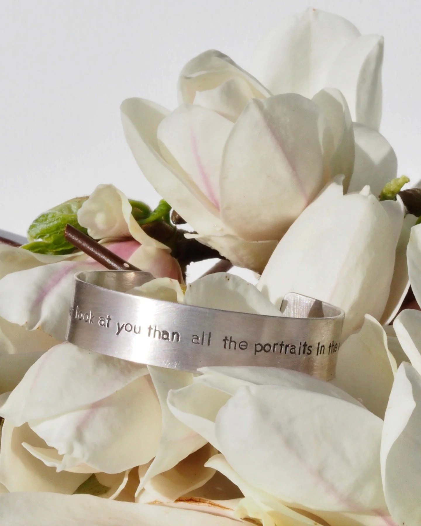 Poetry cuff bracelet in recycled sterling silver. It reads, "I would rather look at you than all the portraits in the world" -- it's from a poem by Frank O&rsquo;Hara. It could be from any poem you wish, as we hand stamp the letters in our 