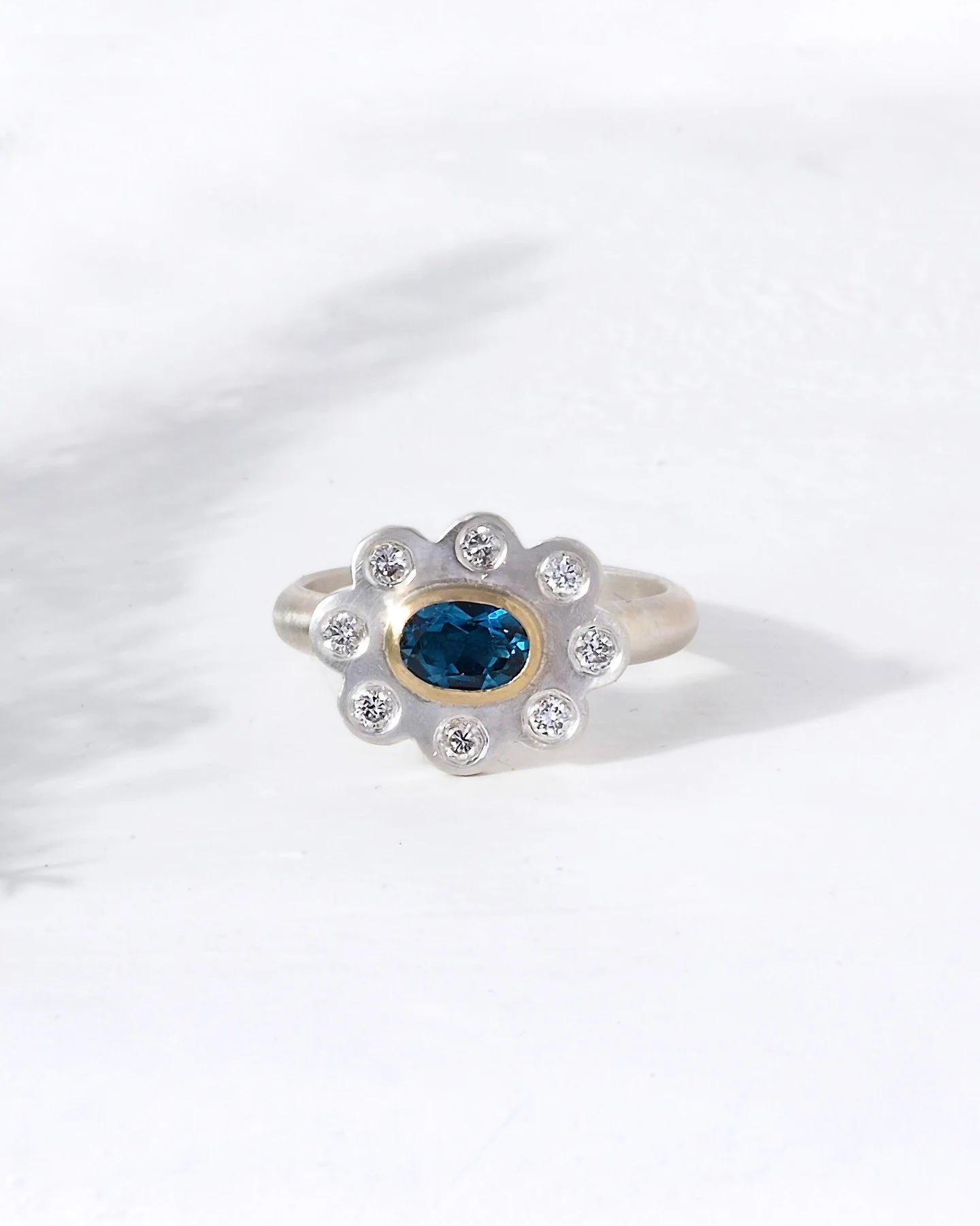 Blue topaz bezel set in 14K recycled gold with an array of ethical diamonds set in sterling sliver. Fabulous floral feelings from this fantastic beauty. 

This ring is bespoke and can be made with different stones and precious metals to perfectly sui