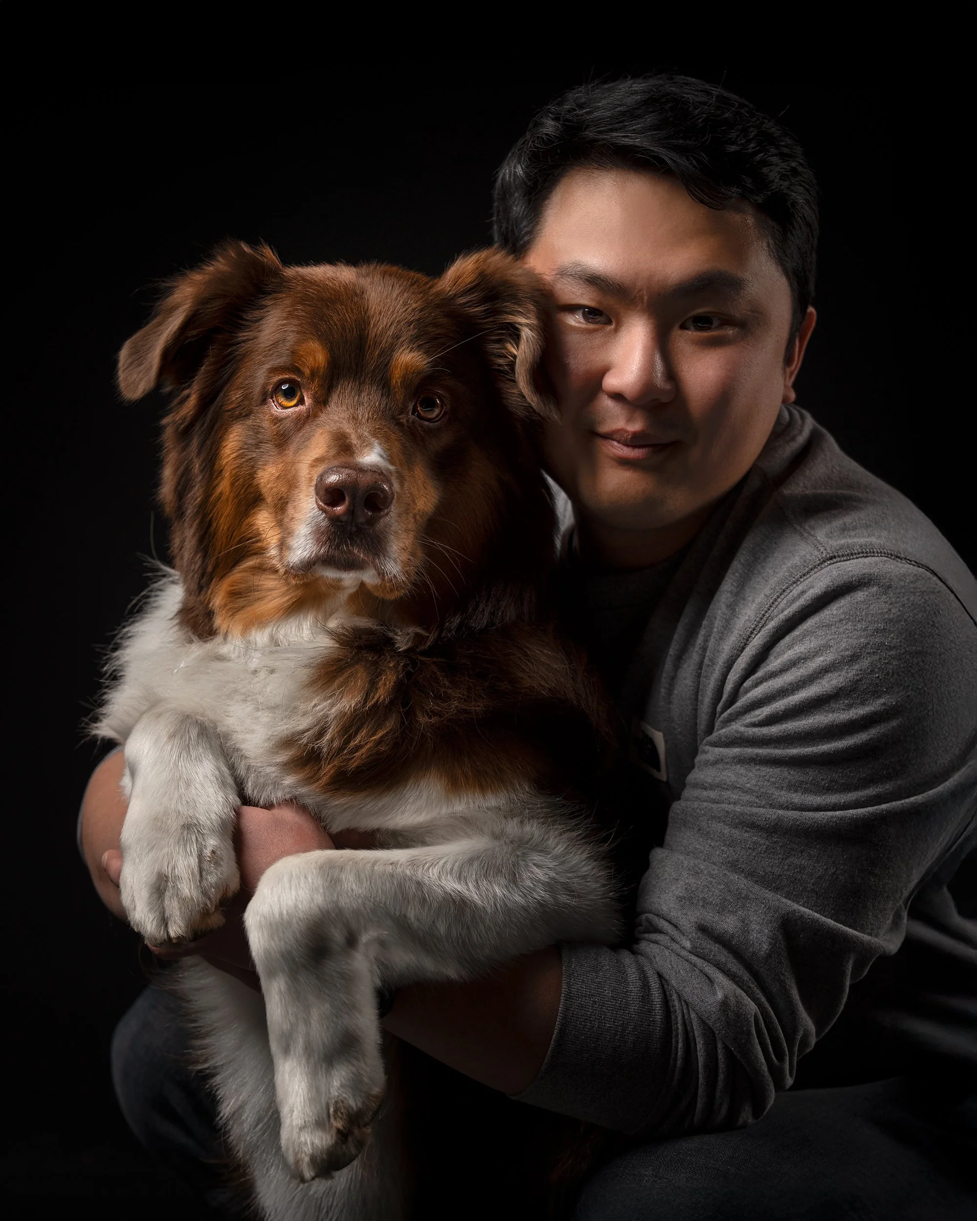 Fine art studio portrait of a man holding his dog, professionally printed and matted in a black frame, photographed by Woof House Studio in New Jersey
