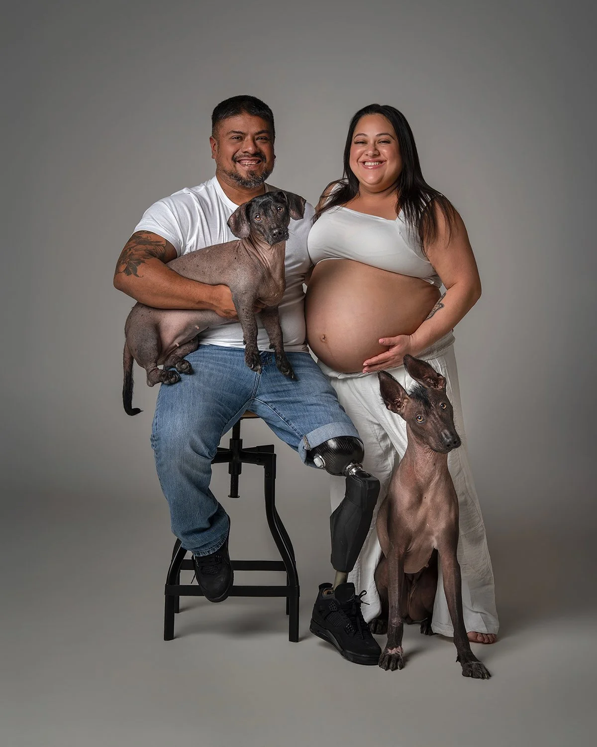 Fine art studio family portrait featuring a pregnant couple with their Xoloitzcuintli dogs, photographed in New Jersey by Woof House Studio. Luxury maternity and dog portrait photography designed as heirloom wall art.