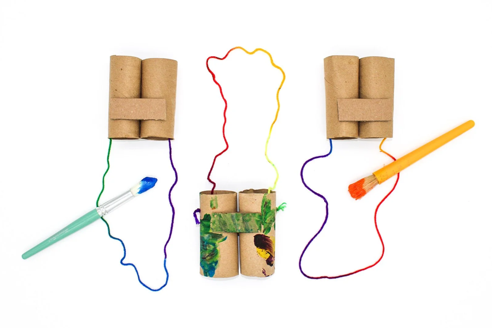Diagrams of human brains made from cardboard toilet paper tubes, with colorful yarn connecting them and paintbrushes as artistic elements.
