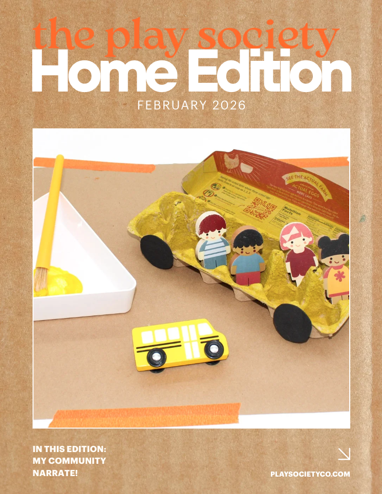 Cover of The Play Society Home Edition February 2026 magazine featuring a craft scene with a paper carton of eggs with paper children figures, a yellow toy bus, and a paintbrush on a brown surface.