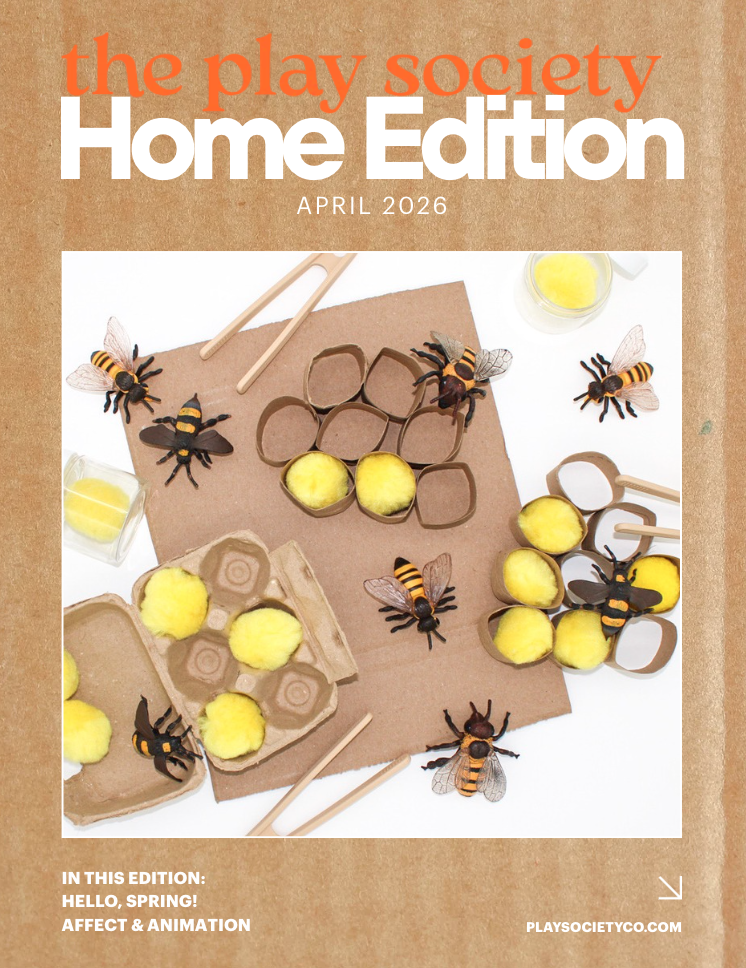 Cover of the Play Society Home Edition magazine, April 2026, featuring a craft scene with toy bees, yellow cotton balls, cardboard, and craft tools.