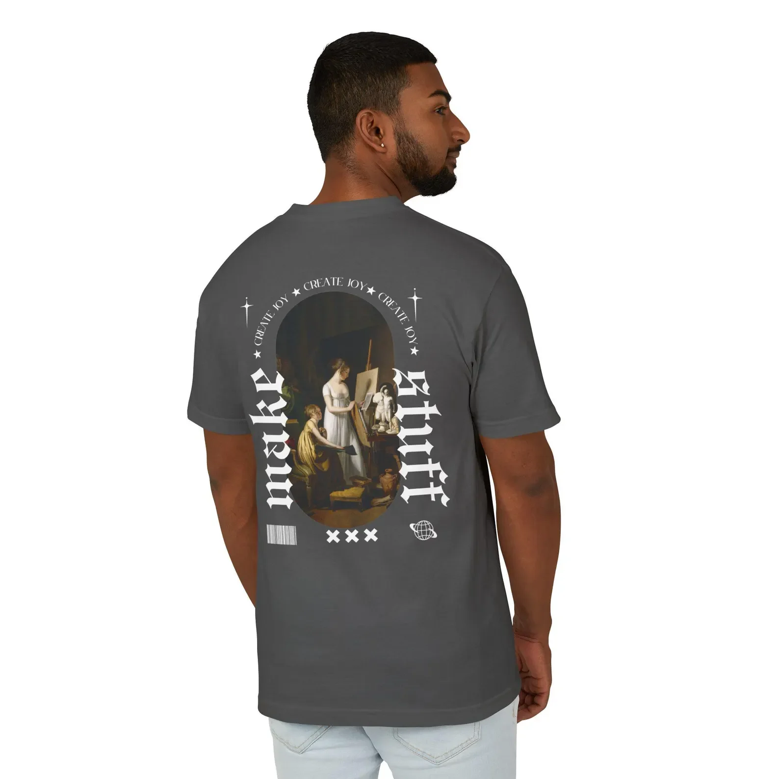 A man stands with his back to the camera, wearing a gray T-shirt with artistic graphic print on the back, including a classical painting of women and various decorative elements.