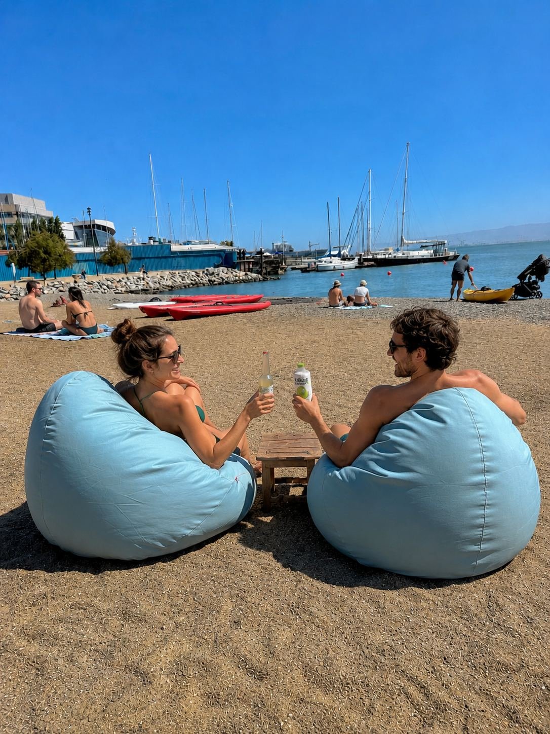 Two people relaxing on rentable beach bean bags at Crane Cove Park