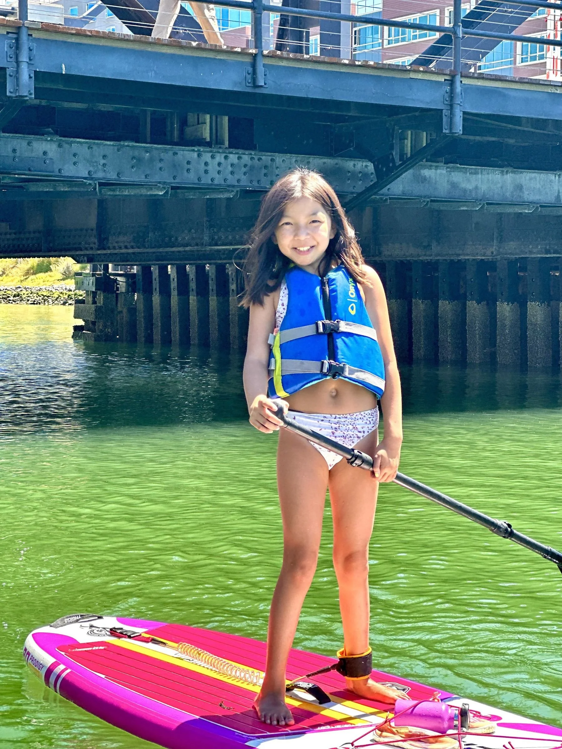 A young camper paddleboarding at the Mission Creek beginner camp