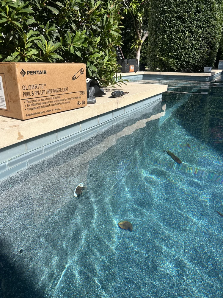 Pool wall fitting and a product box on the adjacent deck.
