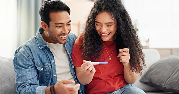 happy couple looking at pregnancy test
